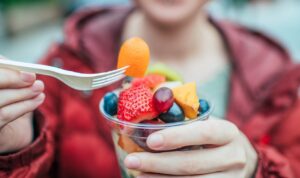 woman eating fruit cup